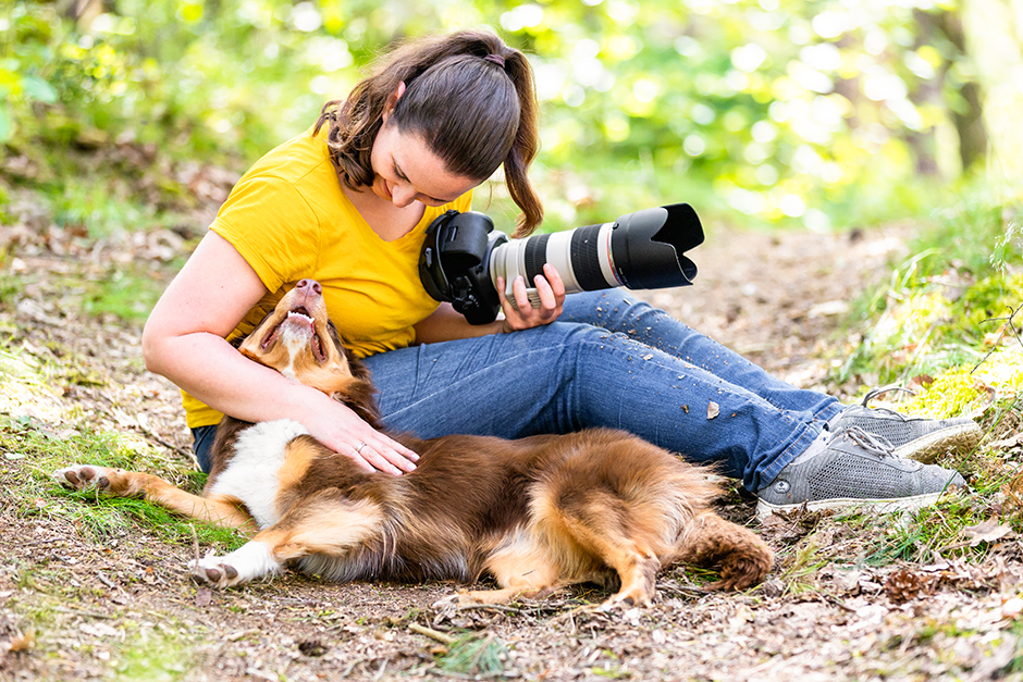 Foto einer Mensch-Tier-Fotografin mit Hund im Wald