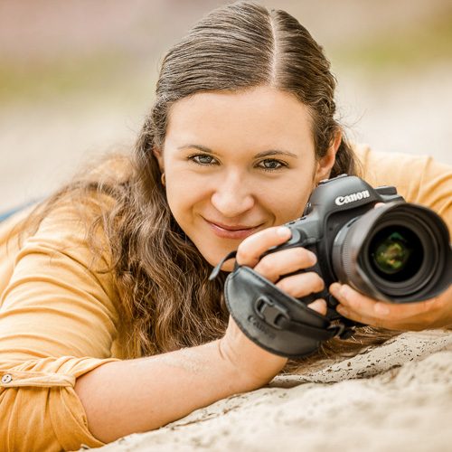 Portrait einer Tierfotografin mit Kamera in der Wiese - Tierfotografie Bremen